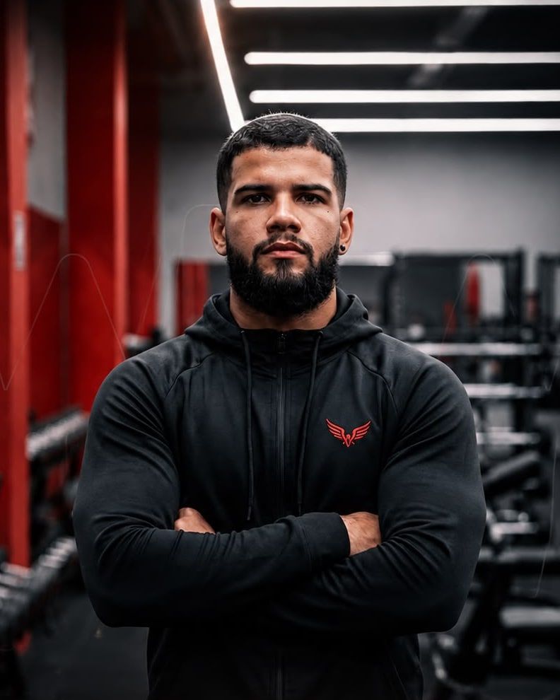 Wanderson Ramos, personal trainer, de braços cruzados em ambiente de academia.